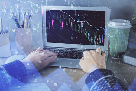 Double exposure of woman hands typing on computer and forex chart hologram drawing. Stock market...