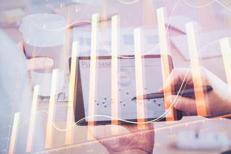 Double exposure of man's hands holding and using a phone and financial chart drawing. Market analysis concept.の写真素材