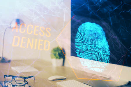 Computer on desktop in office with finger print drawing. Double exposure. Concept of business data security.の写真素材