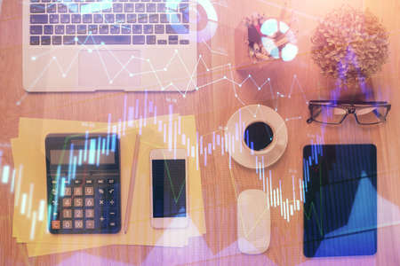Double exposure of forex chart hologram over desktop with phone. Top view. Mobile trade platform concept.の写真素材