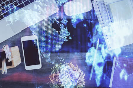 Double exposure of forex chart hologram over desktop with phone. Top view. Mobile trade platform...