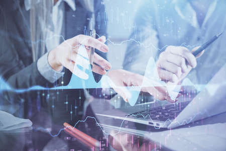 Multi exposure of man and woman working together and financial chart hologram. Business concept....