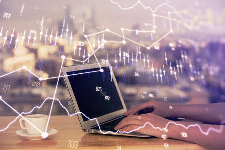 Double exposure of businesswoman hands typing on computer and forex chart hologram drawing....