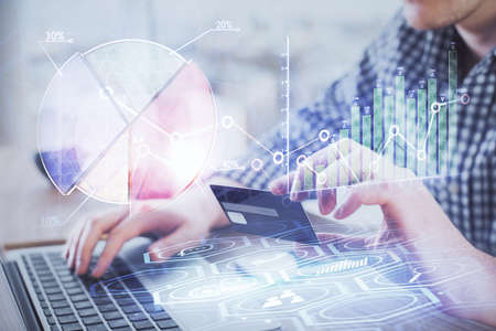 Double exposure of man hands holding a credit card and Forex graph drawing. Stock trading and...