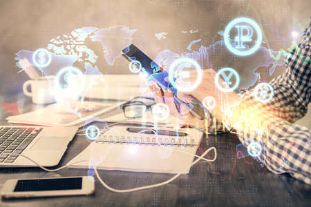 Double exposure of mans hands holding and using a digital device and forex graph drawing. Financial...