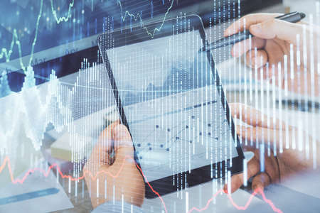 Double exposure of man hands holding and using a phone and financial chart drawing. Market analysis...