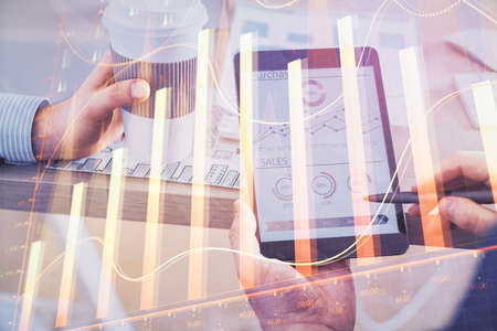 Double exposure of man hands holding and using a phone and financial chart drawing. Market analysis concept.の写真素材