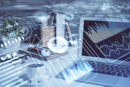 Computer on desktop in office with technology theme hologram. Double exposure. Tech concept.