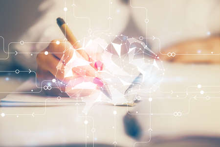 Double exposure of womans writing hand on background with brain hologram. Concept of brainstorming.