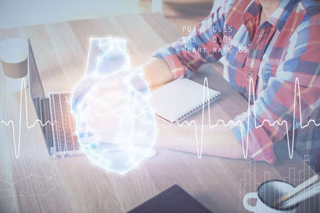 Heart drawing with man working on computer on background. Medical concept. Double exposure.の写真素材