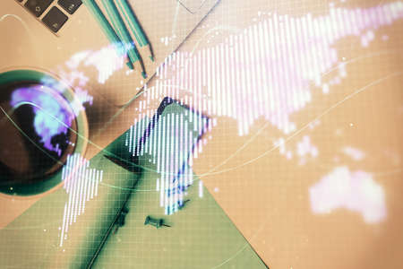 Business theme hologram drawings over computer on the desktop background. Top view. Multi exposure....
