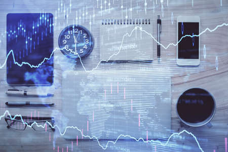 Double exposure of forex graph hologram over desktop with phone. Top view. Mobile trade platform...