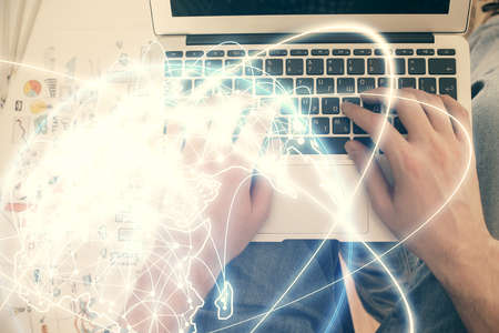 Double exposure of mans hands typing over computer keyboard and business theme hologram drawing. Top...