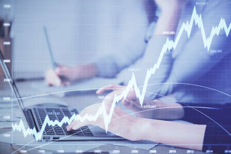 Multi exposure of woman hands typing on computer and financial chart hologram drawing. Stock market...