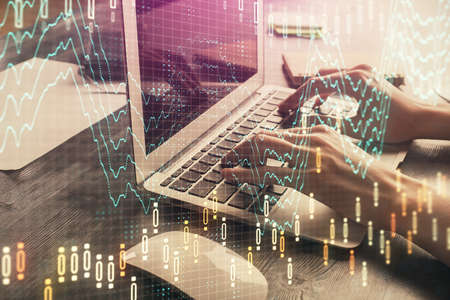 Double exposure of woman hands typing on computer and forex chart hologram drawing. Stock market...