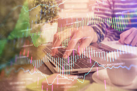 Double exposure of woman hands typing on computer and forex chart hologram drawing. Stock market...