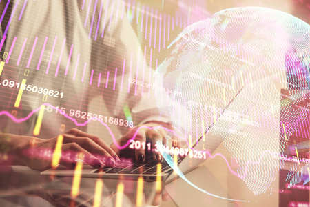 Double exposure of woman hands typing on computer and forex chart hologram drawing. Stock market...
