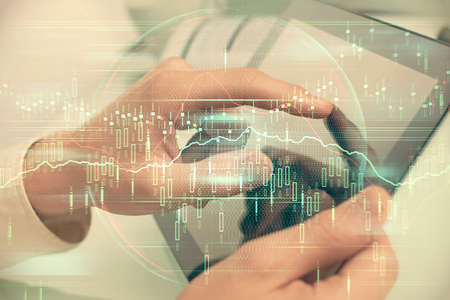 Multi exposure of mans hands holding and using a phone and financial chart drawing. Market analysis...