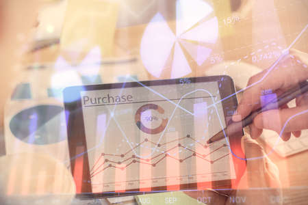 Double exposure of mans hands holding and using a phone and financial chart drawing. Market analysis...