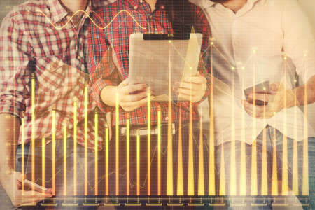 Double exposure of forex graph drawing and man and woman working together holding and using a mobile...