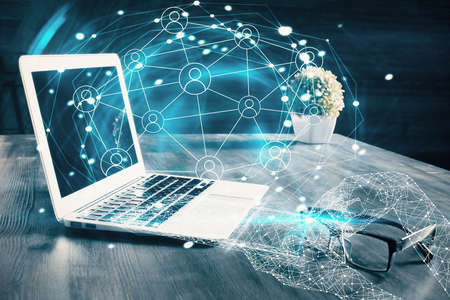 Computer on desktop with social network hologram. Multi exposure. Concept of international people...