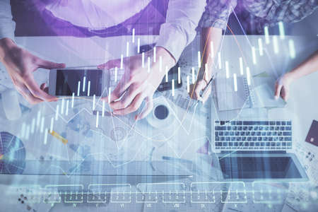 Double exposure of man and woman working together and financial chart hologram drawing. market...