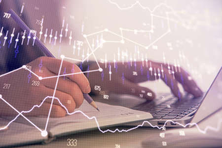 Double exposure of businesswoman hands typing on computer and forex chart hologram drawing....