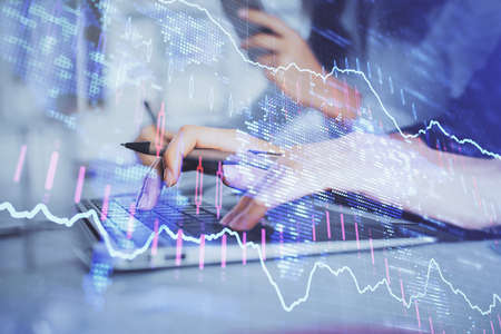 Multi exposure of woman hands typing on computer and financial graph hologram drawing. Stock market...