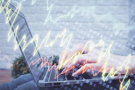 Double exposure of woman hands typing on computer and forex chart hologram drawing. Stock market...