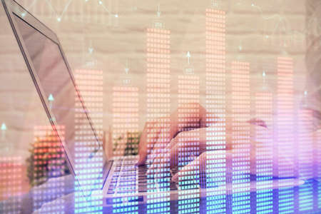Double exposure of woman hands typing on computer and forex chart hologram drawing. Stock market analysis concept.の写真素材