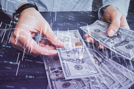 Multi exposure of financial graph drawing hologram and USA dollars bills and man hands. Analysis concept.の写真素材