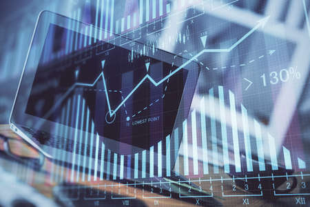 Forex market graph hologram and personal computer on background. Multi exposure. Concept of...