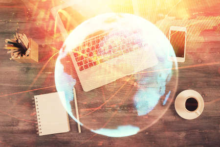 Business theme hologram drawings over computer on the desktop background. Top view. Multi exposure....