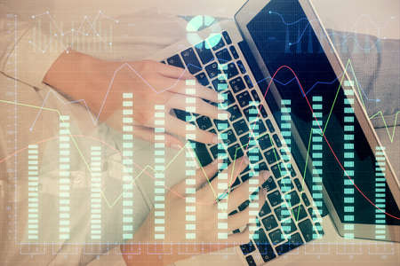 Double exposure of woman hands working on computer and forex graph hologram drawing. Top View....