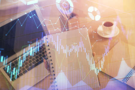 Double exposure of businesswoman hands typing on computer and forex chart hologram drawing. Financial analysis concept.の写真素材