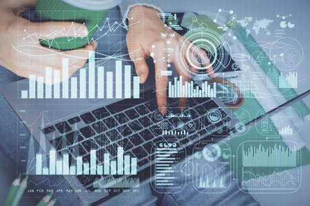 Double exposure of woman hands typing on computer and forex chart hologram drawing. Stock market...