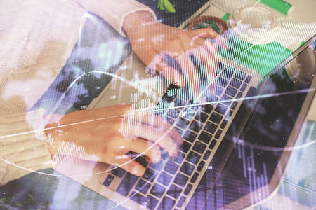 Double exposure of woman hands typing on computer and forex chart hologram drawing. Stock market...