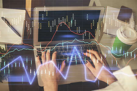 Double exposure of woman hands typing on computer and forex chart hologram drawing. Stock market...