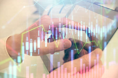 Multi exposure of mans hands holding and using a phone and financial chart drawing. Market analysis...