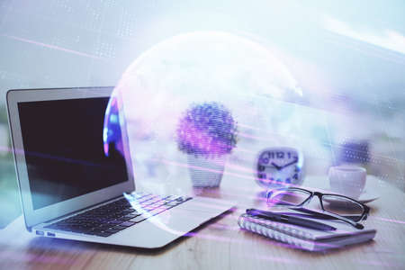 Computer on desktop in office with technology theme hologram. Double exposure. Tech concept.の写真素材