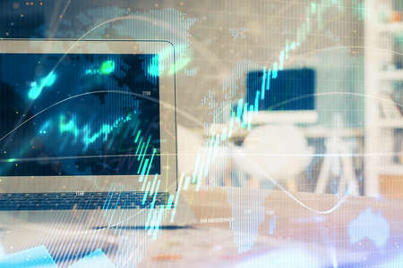 Stock market graph on background with desk and personal computer. Double exposure. Concept of...