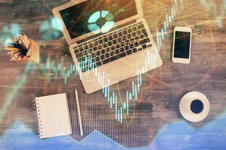 Double exposure of forex chart drawing over table background with computer. Concept of financial...