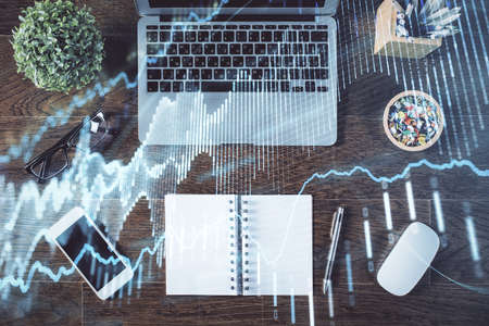 Stock market graph and top view computer on the table background. Double exposure. Concept of...