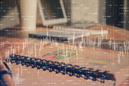 Double exposure of financial graph drawings and desk with open notebook background. Concept of forex...