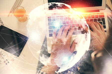 Double exposure of mans hands typing over computer keyboard and business theme hologram drawing. Top view. Financial markets concept.の写真素材