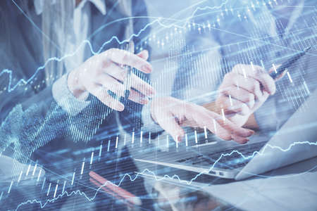 Multi exposure of man and woman working together and financial chart hologram. Business concept....