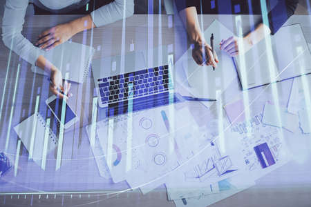 Double exposure of woman hands working on computer and forex graph hologram drawing. Top View....