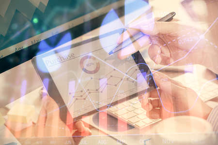 Double exposure of mans hands holding and using a phone and financial chart drawing. Market analysis...