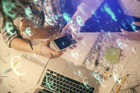 Double exposure of forex graph drawing and man and woman working together holding and using a mobile device. Trade concept.の写真素材