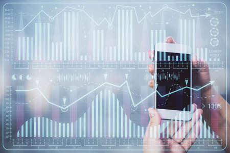 Double exposure of forex graph sketch hologram and woman holding and using a mobile device. Stock market concept.の写真素材